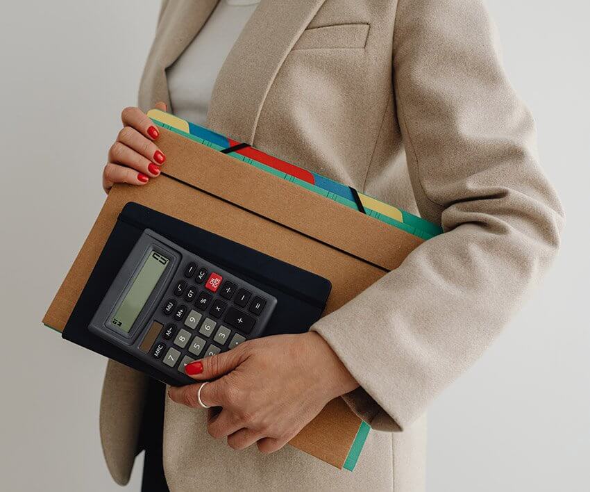 A woman carrying documents while working in an office.